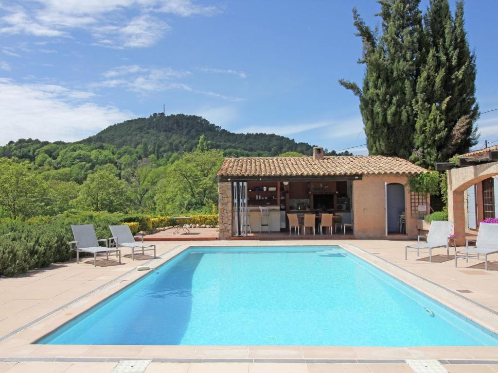 a swimming pool with chairs and a house at Luxurious holiday home with private pool in Salernes