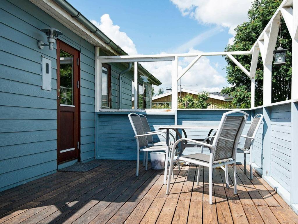 a deck with chairs and a table on a house at 4 person holiday home in Juelsminde in Snaptun