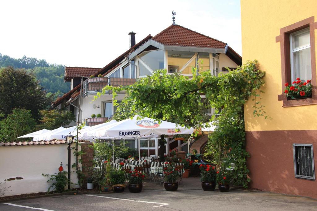 un edificio con un paraguas y flores delante de él en Hotel- Restaurant Zum Schwan en Waldfischbach-Burgalben