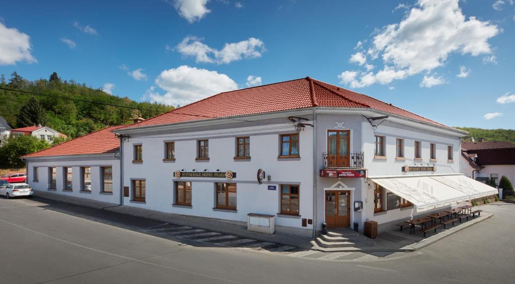 a large white building with a red roof at Restaurace Hotel Praha in Nižbor