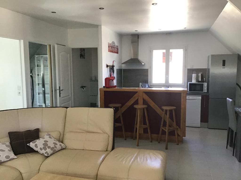 uma sala de estar com um sofá e uma cozinha em chez diane em Barbeville
