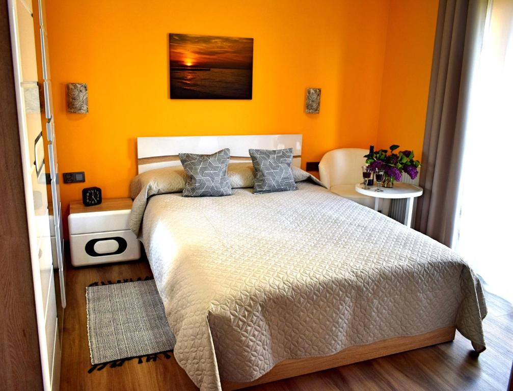 a bedroom with orange walls and a bed with blue pillows at Apartament Sianożęty in Sianozety