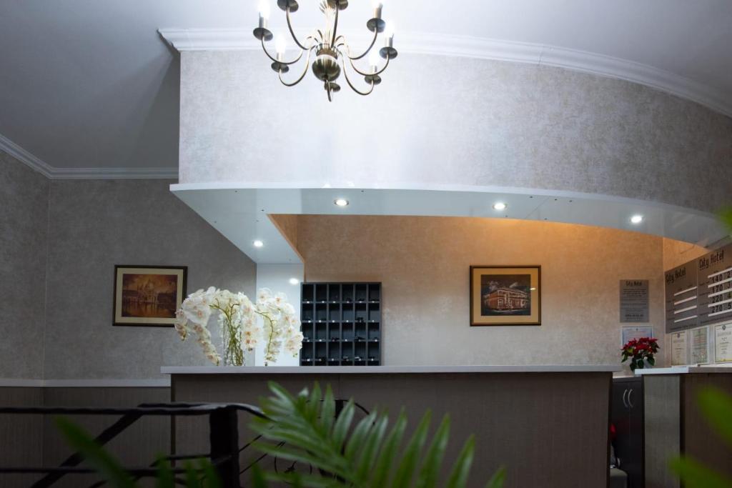 a chandelier hangs from the ceiling of a waiting room at Carnival City Hotel Oradea in Oradea