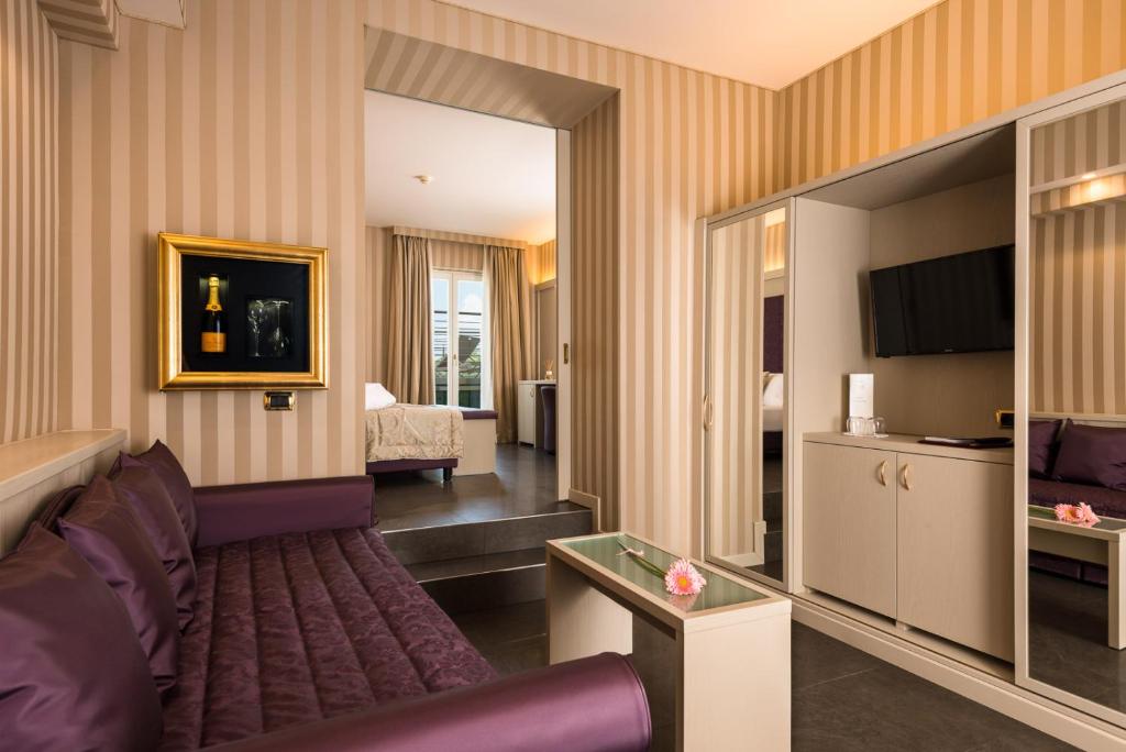 een hotelkamer met een bank en een slaapkamer bij Villa Nicolli Romantic Spa Resort - Adults Only in Riva del Garda