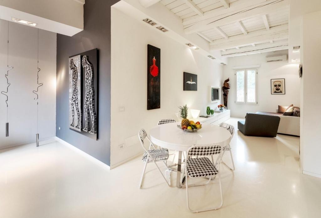 una sala de estar blanca con mesa blanca y sillas en Charming Flat in centro a Ferrara con posto auto, en Ferrara