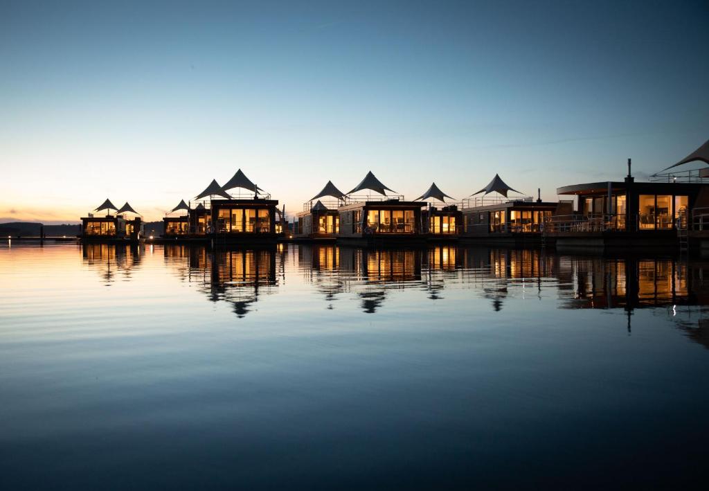 un gruppo di case sull'acqua al tramonto di Floating Village Brombachsee a Ramsberg