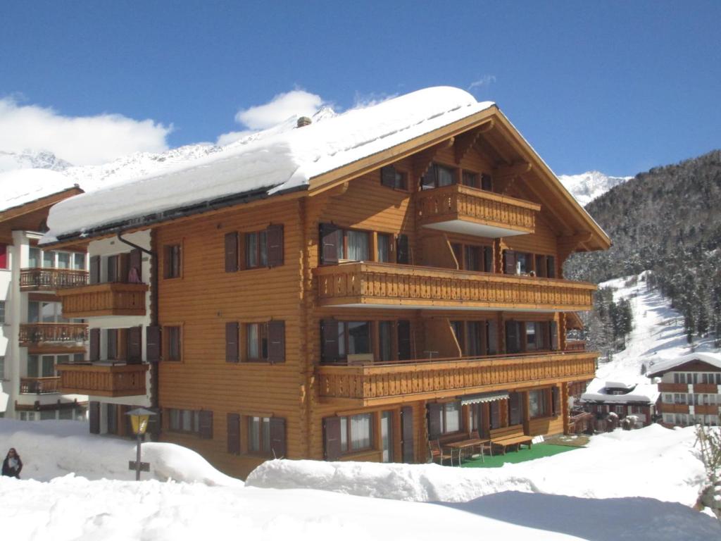 ein großes Holzgebäude mit Schnee darauf in der Unterkunft Haus Avalanche in Saas-Fee