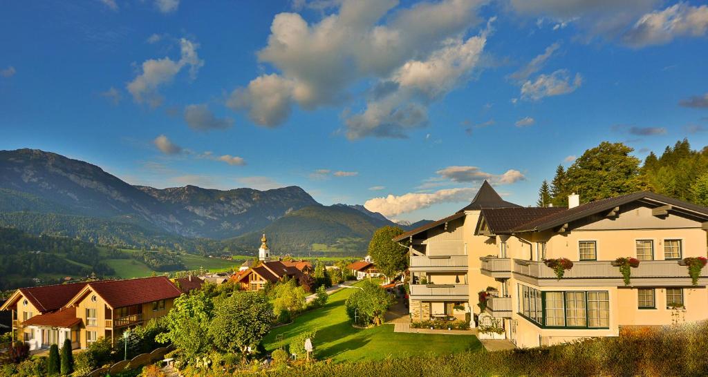 une maison dans un village avec des montagnes en arrière-plan dans l'établissement Cafe Pension Kitzer, à Haus im Ennstal