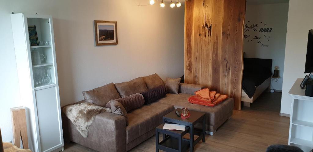 a living room with a brown couch and a table at Harz Zeit in Altenau