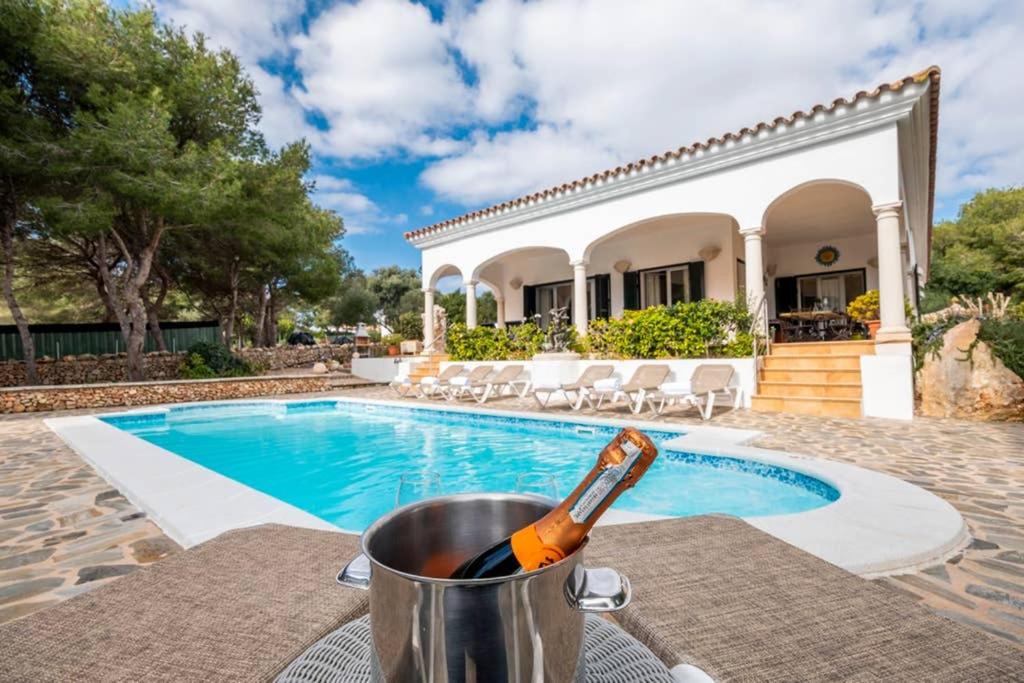 a bottle of beer in a bucket next to a swimming pool at Villa Luxury in Binibeca