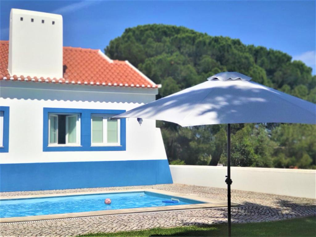 um guarda-chuva branco sentado ao lado de uma casa em Azul Coruche em Coruche