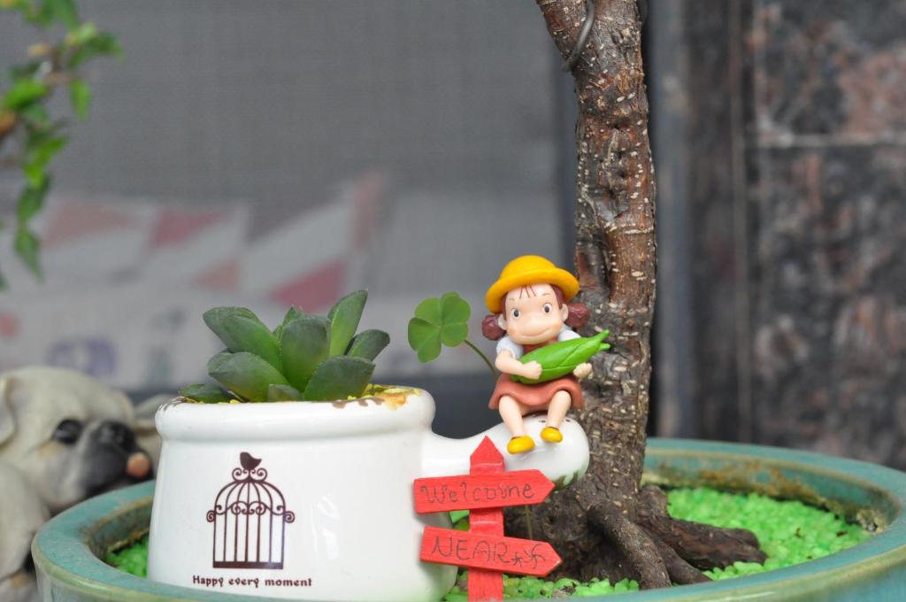 una figurita en miniatura de un niño sentado en una planta en NEAR B&B en Hualien