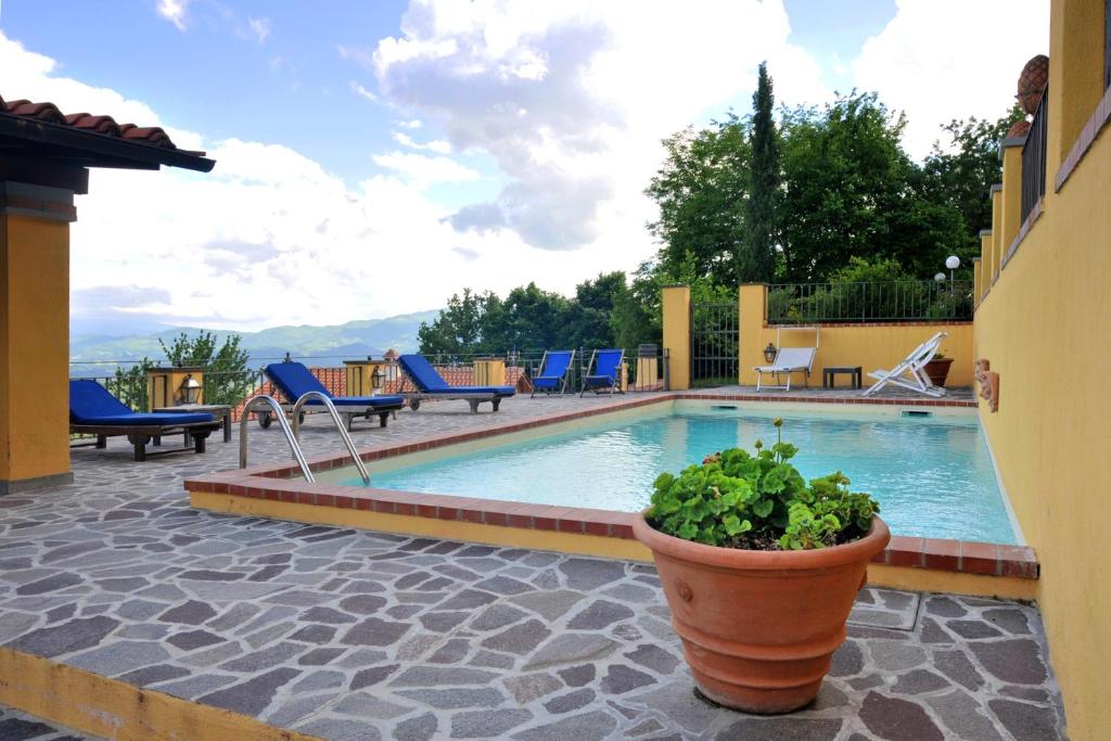 a pool with chairs and a potted plant next to it at 2 bedrooms house with shared pool enclosed garden and wifi at Gattaia in Gattaia