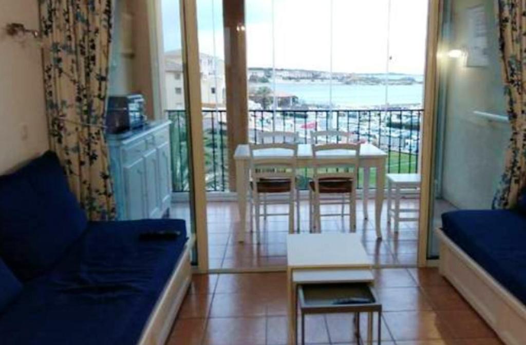 d'un salon avec un canapé et une table ainsi que d'un balcon. dans l'établissement Appartement charmant près de la plage et une piscine (32 m²), à Six-Fours-les-Plages