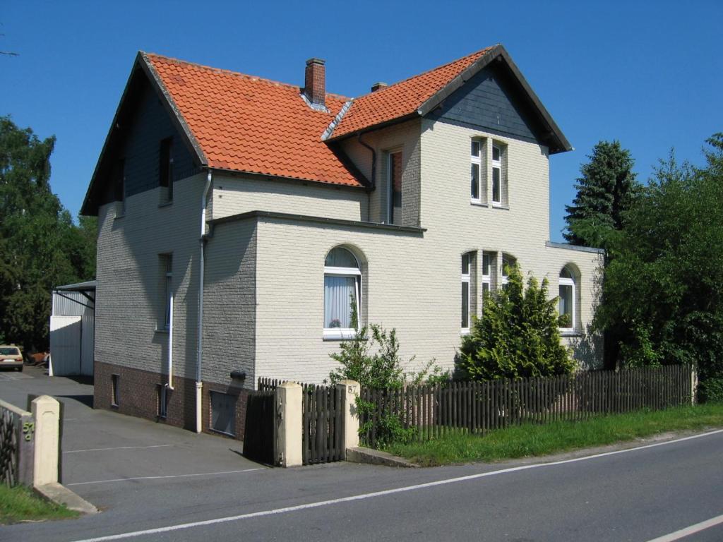 a white house with an orange roof on a street at Ferienwohnung Waschinski in Goslar