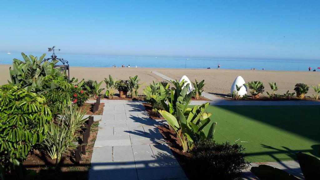 a walkway leading to the beach with a beach in the background at Los Nidos Sea Pretty&Beach- La Carihuela in Torremolinos