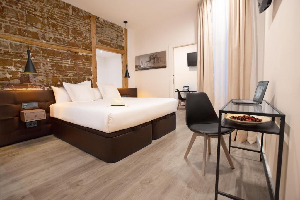 a hotel room with a bed and a table and a chair at Woohoo Rooms Fuencarral in Madrid