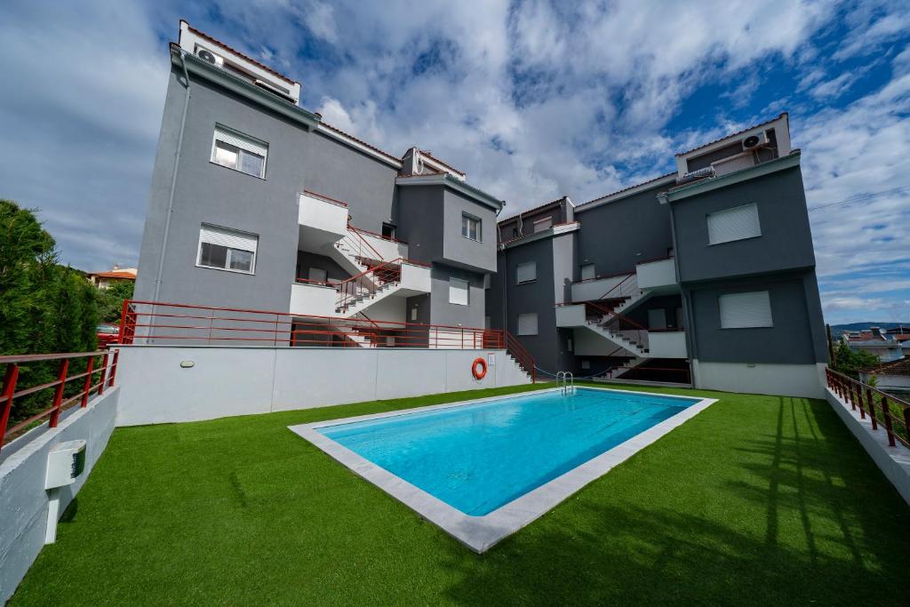 an apartment building with a swimming pool in the yard at Hermes Design Suites in Iraklitsa