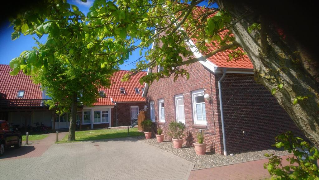 a brick building with potted plants in front of it at Nordsee-Brise in Dornumersiel