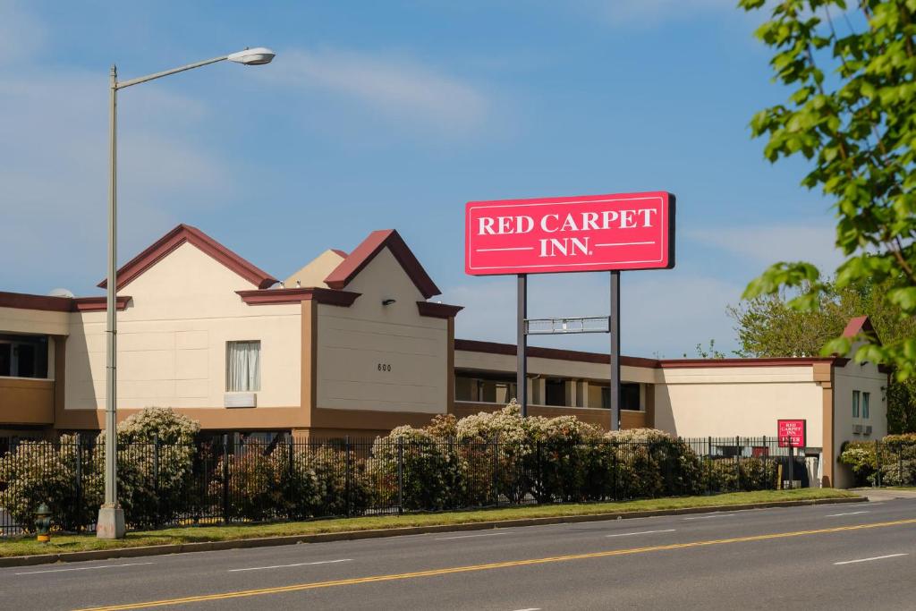 a red carport inn sign in front of a building at Red Carpet Inn Washington DC in Washington, D.C.
