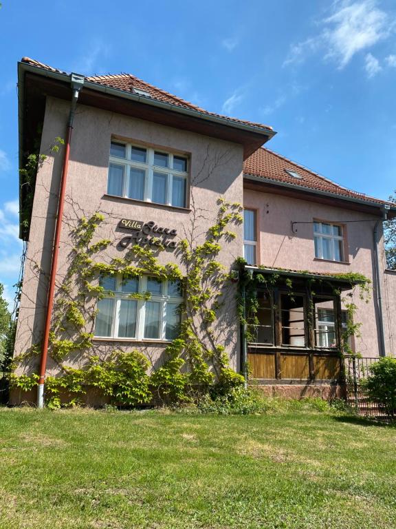 a house with ivy growing on the side of it at Villa Stara Apteka in Srebrna Góra