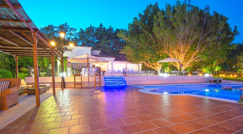 una piscina con sedie e ombrelloni su un patio di Finca El Campo a Algeciras