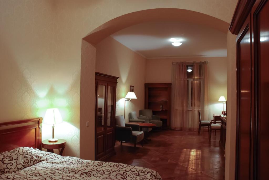 Habitación de hotel con cama y sala de estar. en Central Apartments Lviv en Leópolis
