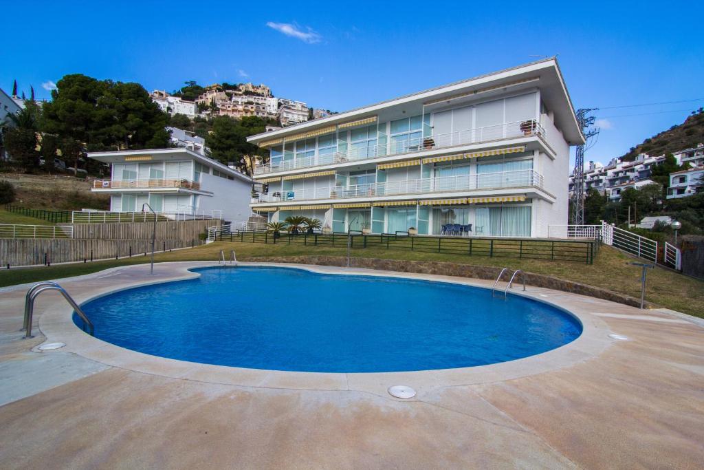 una casa con piscina frente a un edificio en Agi Residencial Almadraba, en Roses