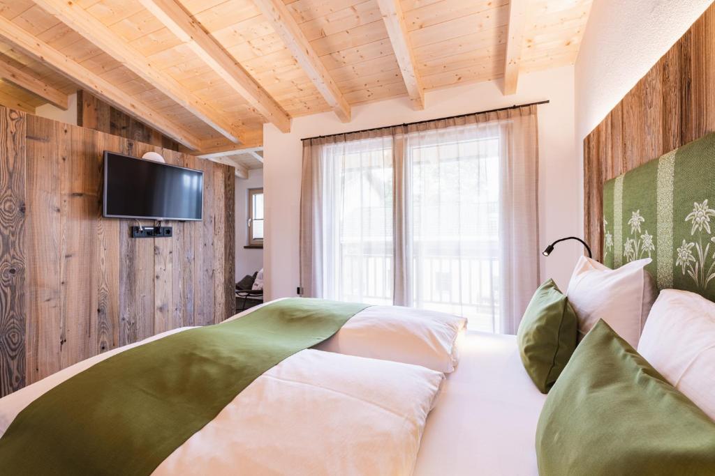 - une chambre avec un lit et une télévision murale dans l'établissement Michelerhof - kinderfreie Unterkunft, à Lavant