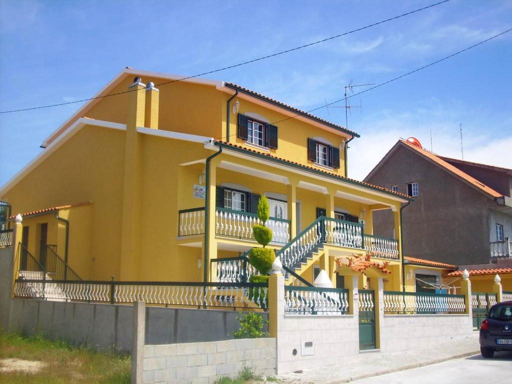 a yellow house with balconies on a street at 4 bedrooms house with city view enclosed garden and wifi at Corticada in Cortiçada