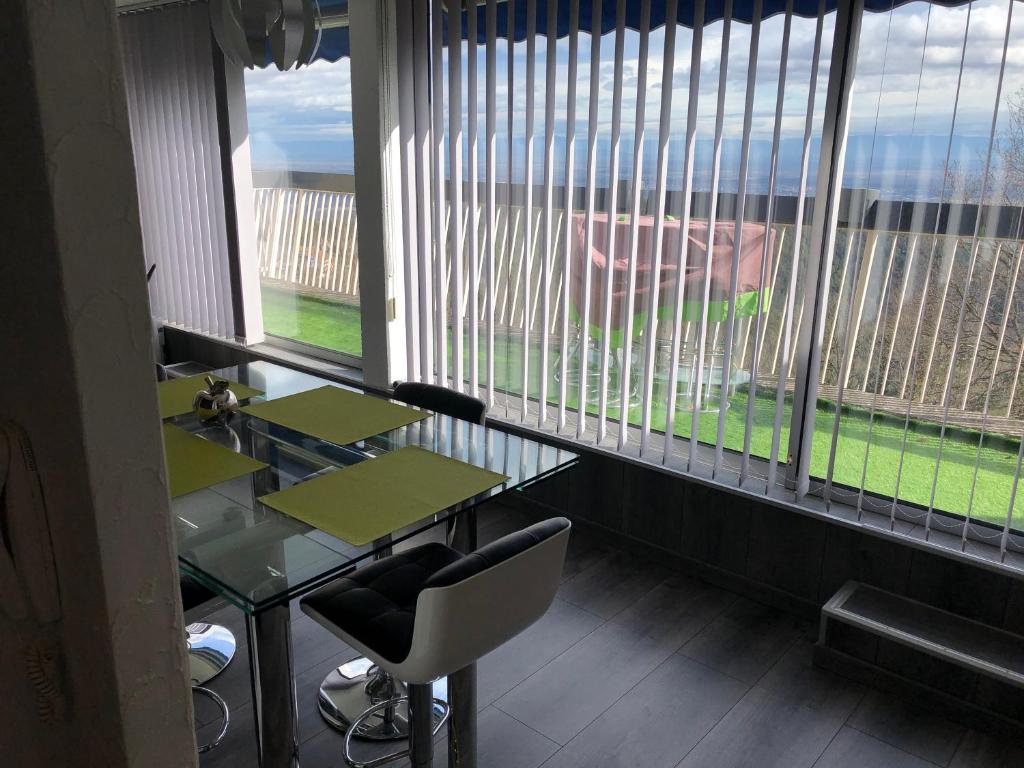 a room with a table and chairs and windows at Petit moment de Bonheur in Turckheim