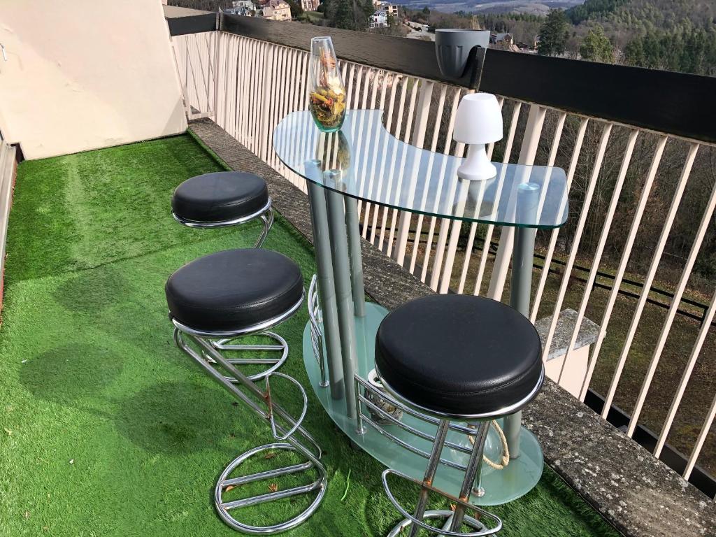 a table and stools on a balcony with grass at Petit moment de Bonheur in Turckheim