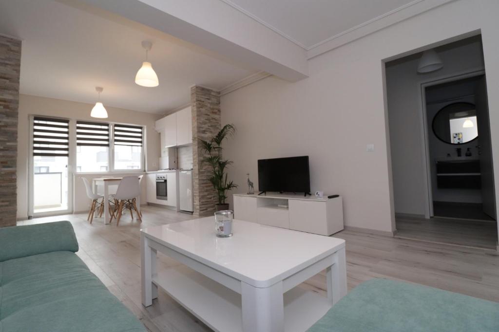 a living room with a white table and a tv at Apartament 2 camere Anto in Sibiu