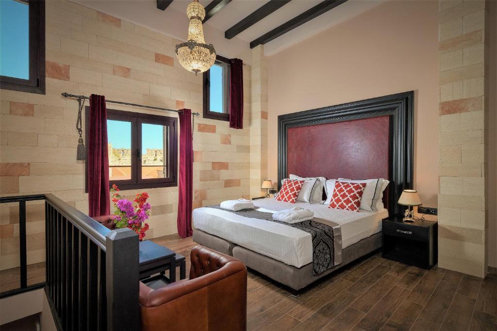 a bedroom with a bed and a chair in it at Grand Master Suite in Rhodes Town