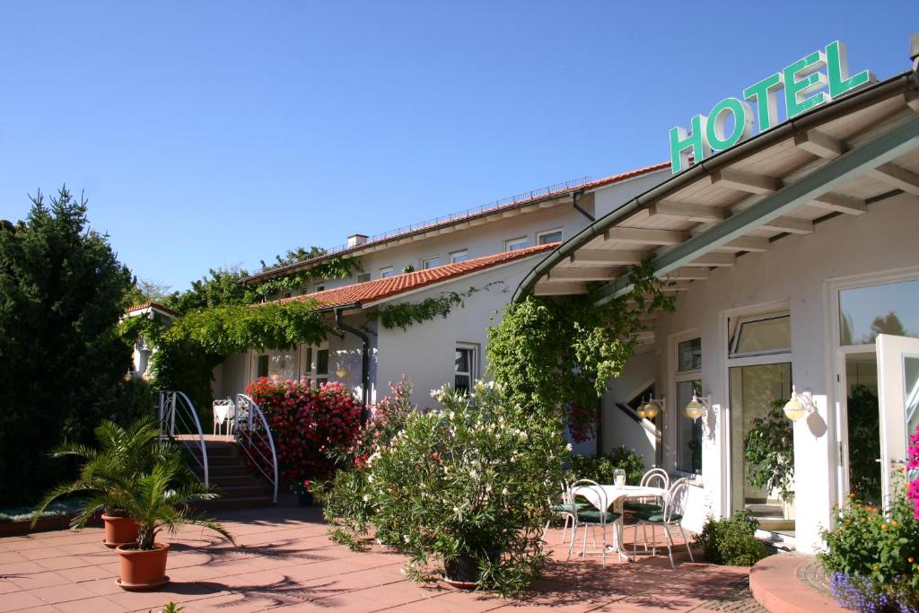 ein Hotel mit Tischen und Stühlen außerhalb in der Unterkunft Lindner's Apartment in Bellheim