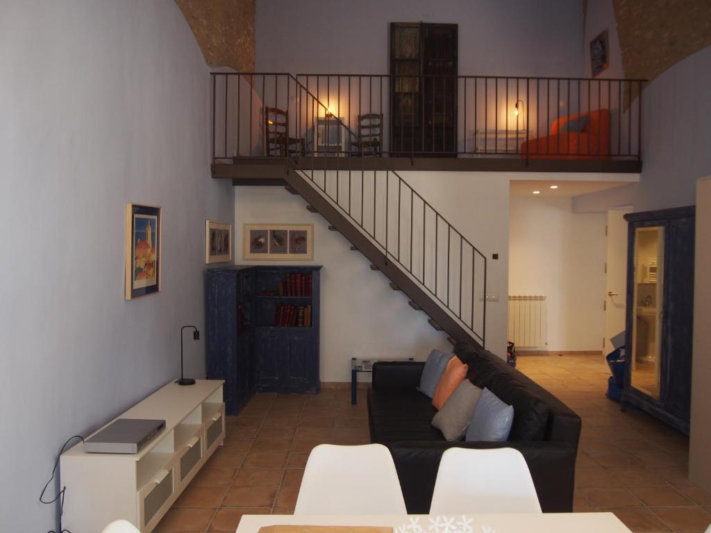 sala de estar con sofá y escalera en Plaça Major 17 2n 2a Apartament al centre de Banyoles, en Banyoles