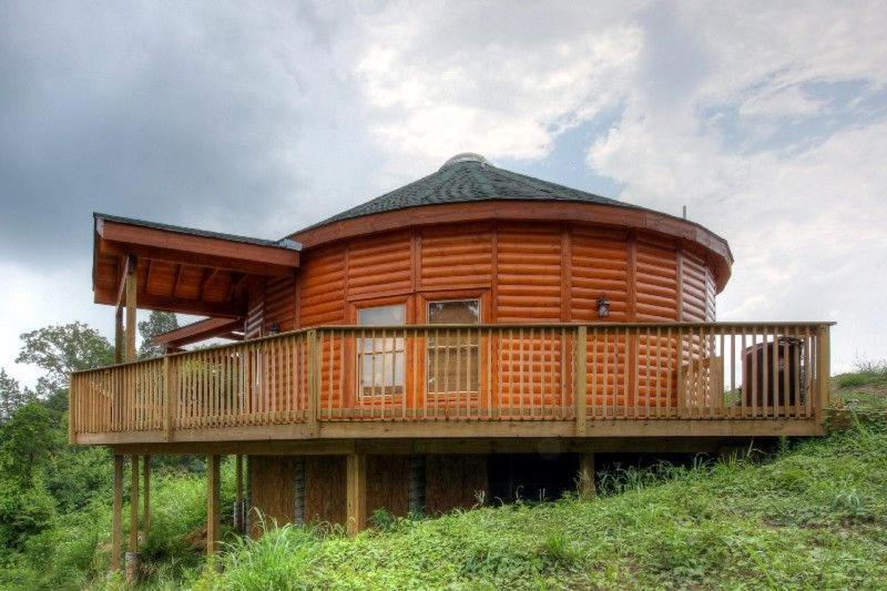 eine Holzhütte mit einer Terrasse auf einem Hügel in der Unterkunft Heavenly View in Sevierville