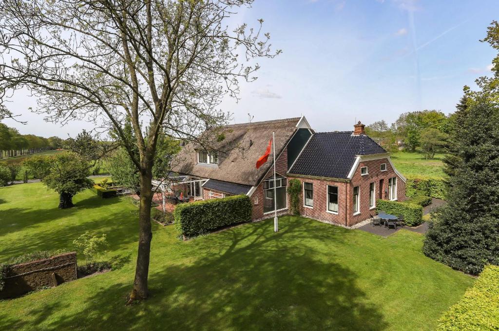 an aerial view of a house on a green yard at Kindvriendelijk appartement de Hooge Stukken onder de rook van Groningen in Eelde-Paterswolde