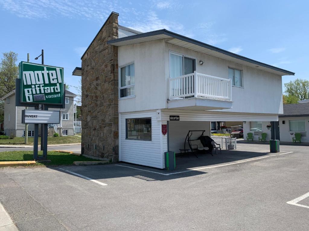 Un motel di fronte a un edificio con diciotto cartelli di Motel Giffard a Québec