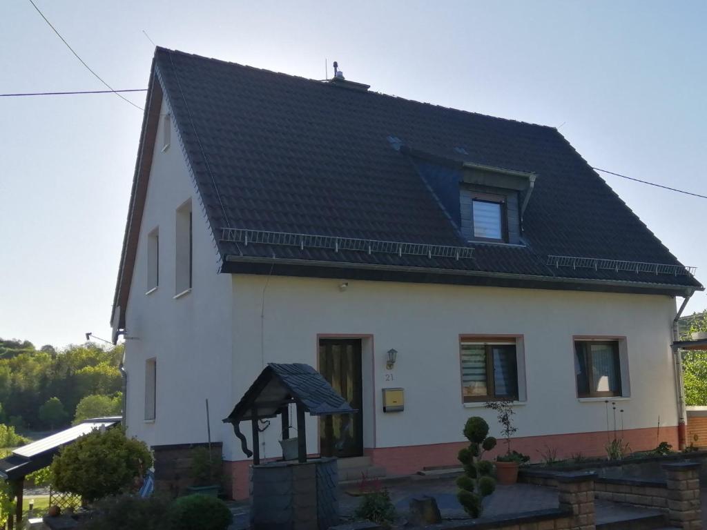 a white house with a black roof at Ferienwohnung Wiesengrund in Hahnstätten