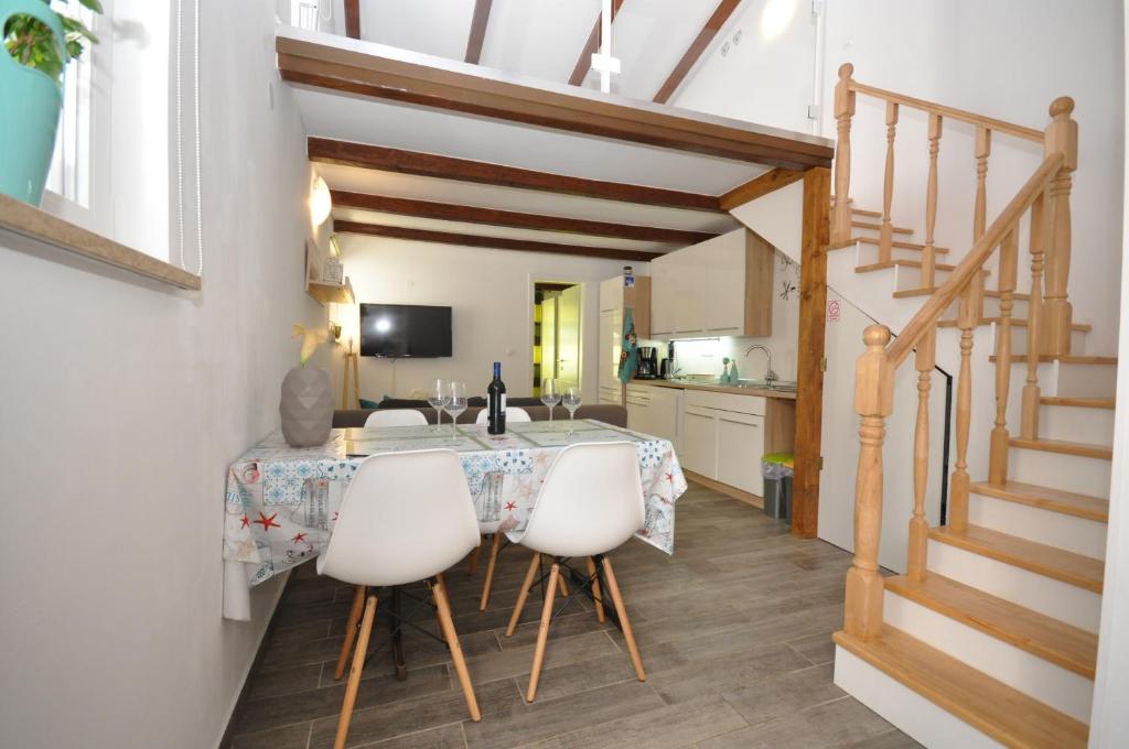 a kitchen and dining room with a table and chairs at New Lux Apartman Kala in Poreč