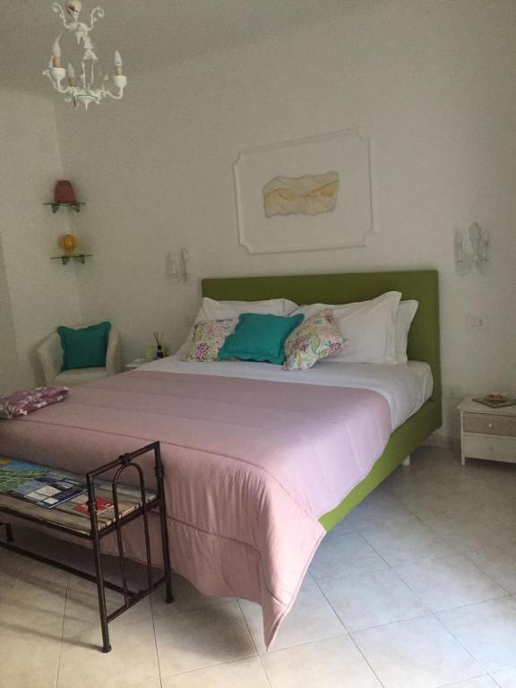 a bedroom with a large bed with a green headboard at Sorrento Penthouse Suites in Sant'Agnello