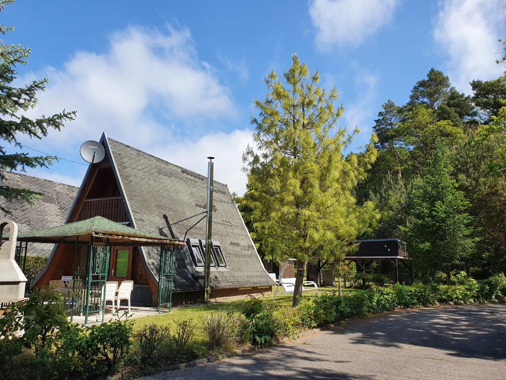 una pequeña casa con techo de gambrel y entrada en Ferienhaus am Helenesee 1, en Frankfurt de Oder