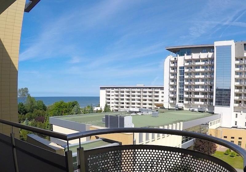 a balcony with a view of a building and the ocean at ARKA Apartament Deluxe 503 z widokiem na morze in Kołobrzeg