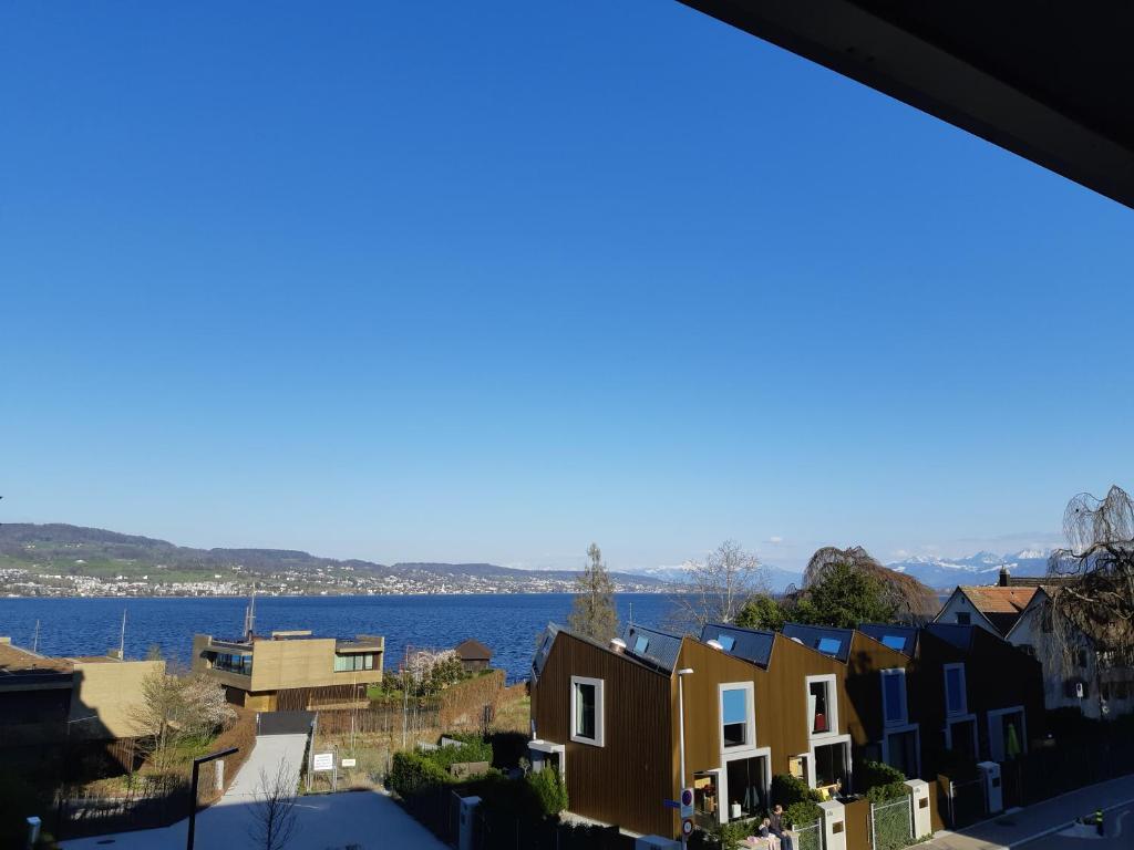 a view from a balcony of houses and the water at Esther's Homestay - Big Room - 26 Square Meters in Horgen