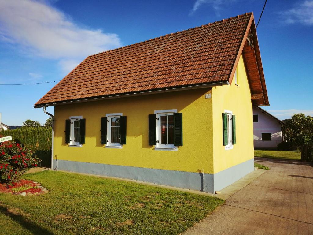Ferienhaus Raiter Südsteiermark في Weitersfeld an der Mur: منزل أصفر بسقف بني
