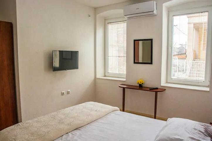 - une chambre avec un lit et une télévision murale dans l'établissement Apartments near the Old Church, à Prilep