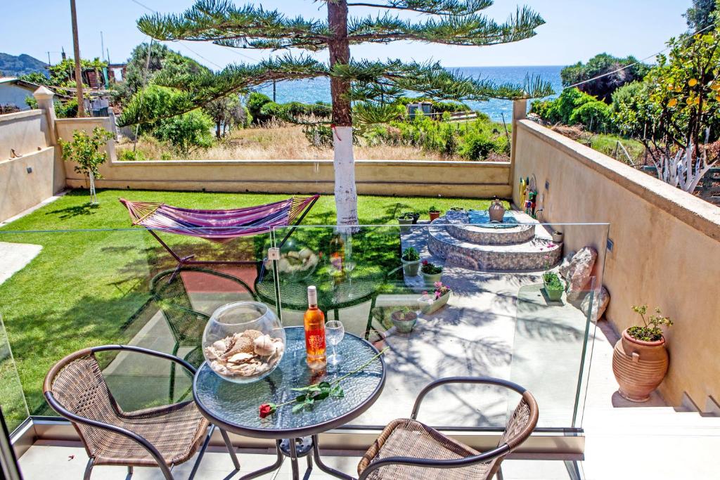 eine Terrasse mit einem Tisch und Stühlen sowie Meerblick in der Unterkunft FilipposResort in Agios Gordios