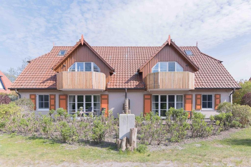 ein Haus mit einem Dach mit Holzbalkonen darauf in der Unterkunft Haus WINDFLÜCHTER Whg. LF 6.1 in Wustrow