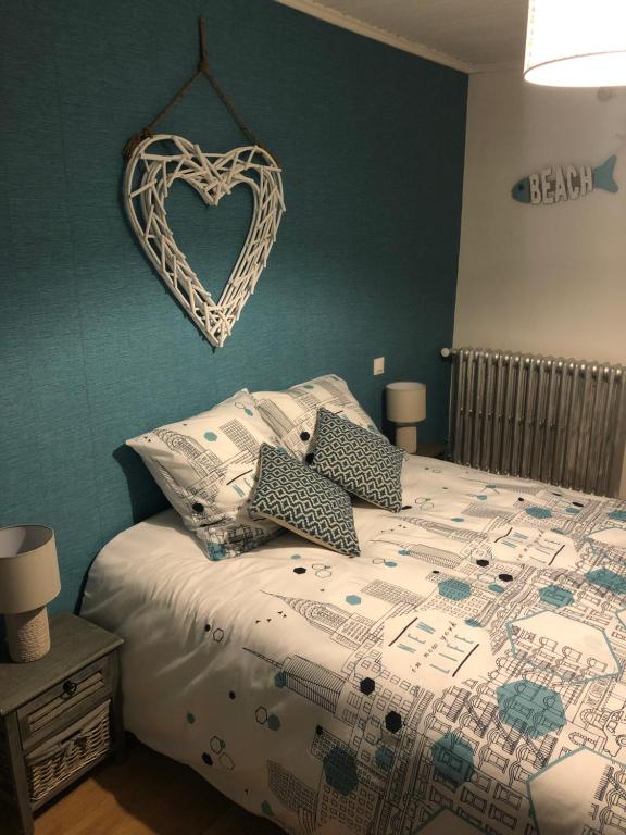 um quarto com uma cama com um sinal de coração na parede em Auberge des platanes em Villevocance